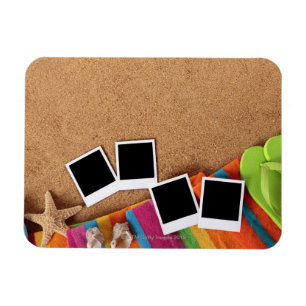 Beach scene with blank photo prints, towel, magnet