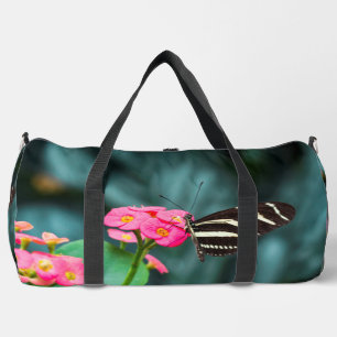 Beautiful butterfly on a pink flower duffle bag