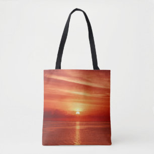 Beautiful colourful sunrise at the sea with dramat tote bag