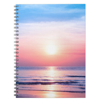 Beautiful morning sunrise, blue sea, pink sky, whi notebook