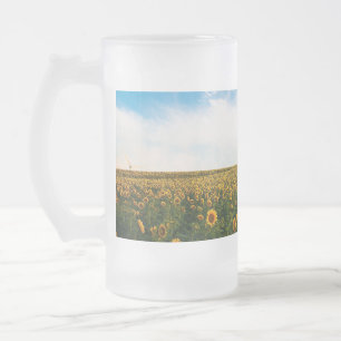 beautiful sun flowers field with cloudy blue sky a frosted glass beer mug