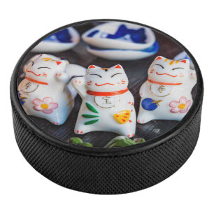 Beckoning cat figurines hockey puck