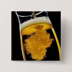 Beer been poured into glass, studio shot 15 cm square badge