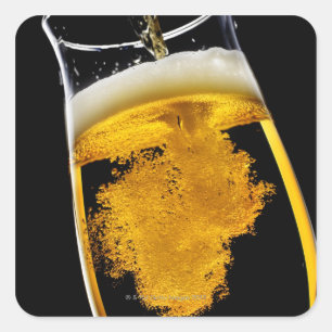 Beer been poured into glass, studio shot square sticker