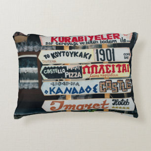 BEIGE RED AND BROWN SIGNAGES ON BEIGE STAND AT DAY DECORATIVE CUSHION