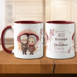 Best Grandpa and Grandma Ever Holding an Umbrella Mug<br><div class="desc">This endearing design encapsulates the enduring love between a cherished grandfather and a grandmother. The scene showcases the senior couple holding each other close beneath a vibrant red umbrella adorned with heart motifs, symbolising their strong bond. Centred amidst this heartfelt scene is the message "Best Grandpa and Grandma Ever, "...</div>