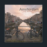Bicycles at sunset in Amsterdam Magnet<br><div class="desc">Souvenir photo magnet with some bicycles locked to the bar of a bridge over Prinsengracht canal lined by traditional canal houses at sunset in the city centre of Amsterdam in the Netherlands with the text 'Amsterdam, The Netherlands'.</div>