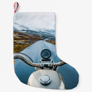 Biker rides a motorcycle on a slippery road throug small christmas stocking
