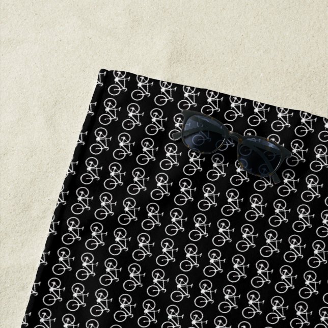 biking pattern of white bicycles on black beach towel (In Situ)