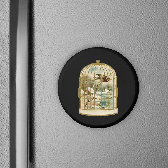 Bird In Cage Winter Scene Magnet (Golden birdcage with winter cabin scene inside bird on branch on black round magnet.)