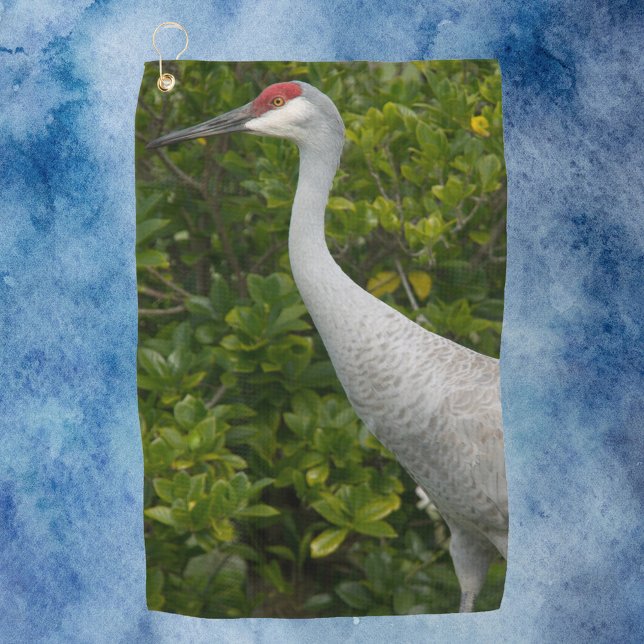 Bird Sandhill Crane Photograph Golf Towel (A golf towel with a photograph of a sandhill crane bird in front of green leaves.)