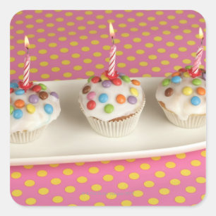 Birthday muffins with icing, sprinkles and square sticker