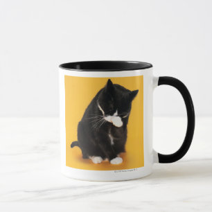 Black and White Cat cleaning face with paw Mug