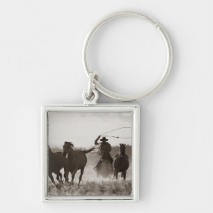 Black and White photo of a Cowboy Lassoing Horses Key Ring