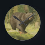 Black Bear Stepping on a Tree Trunk Round Clock<br><div class="desc">This fine art print by Oliver Kemp illustrates a brown bear stepping on a fallen tree in a forest. The pastel green colours are calming for the eye and create a nice warm feeling of the awakening nature in the spring. A great addition to any rustic home decor!</div>
