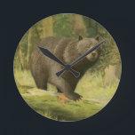 Black Bear Stepping on a Tree Trunk Round Clock<br><div class="desc">This fine art print by Oliver Kemp illustrates a brown bear stepping on a fallen tree in a forest. The pastel green colours are calming for the eye and create a nice warm feeling of the awakening nature in the spring. A great addition to any rustic home decor!</div>