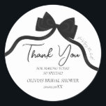 Black bow she's tying the knot bridal shower classic round sticker<br><div class="desc">Host an unforgettable bridal shower with this elegant "She's Tying the Knot" sticker featuring a stylish black bow design. Perfect for a modern black-and-white theme, this sticker blends chic sophistication with timeless charm. Fully customisable, it allows you to easily update the bride's name, event date, location, and other details to...</div>
