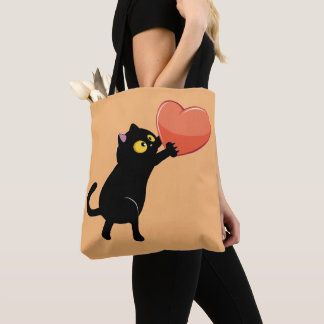 Black cat holding heart tote bag