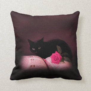 black cat with book and rose pillow