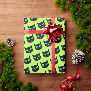 Black cat with green eyes on light lime green wrapping paper
