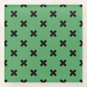Black cross stitches on green glass coaster