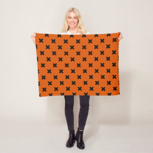 Black cross stitches on orange fleece blanket