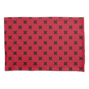 Black cross stitches on red pillowcase