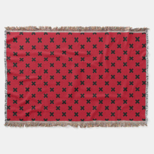 Black cross stitches on red throw blanket