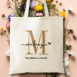 Black Gold Monogram Initial Script Name Heart Tote Bag<br><div class="desc">Introducing the Black Gold Monogram Initial Script Name Heart Tote Bag, a chic and elegant accessory perfect for weddings, bridesmaids, maid of honour, or even the bride herself. This stylish tote features a stunning black and gold colour scheme that adds a touch of sophistication to any outfit. The monogrammed initial...</div>