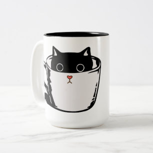 Black kitten with red nose hiding in a cup