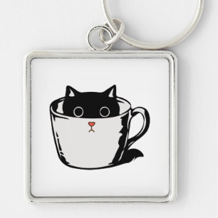 Black kitten with red nose hiding in a cup key ring