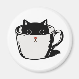 Black kitten with red nose hiding in a cup magnet