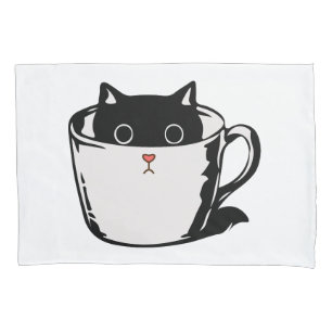 Black kitten with red nose hiding in a cup pillowcase