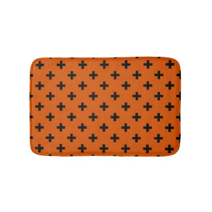Black polka crosses on orange bath mat