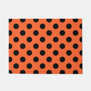 Black polka dots on orange doormat