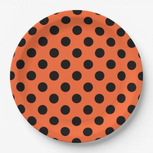 Black polka dots on orange paper plate