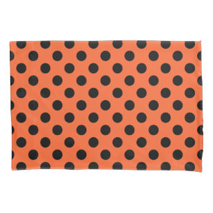 Black polka dots on orange pillowcase