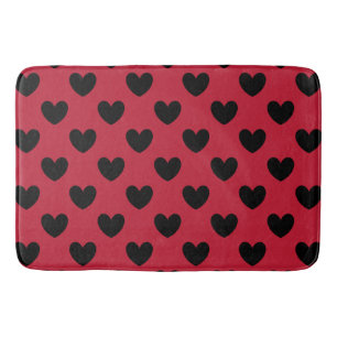 Black polka hearts on red bath mat
