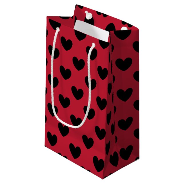 Black polka hearts on red small gift bag (Front Angled)