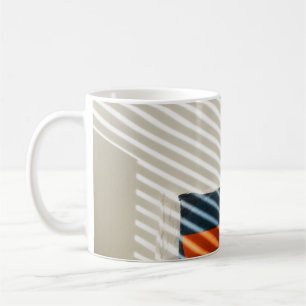 Black red and white plaid textile on white bed coffee mug
