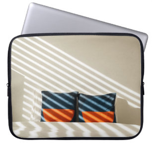 Black red and white plaid textile on white bed laptop sleeve