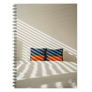 Black red and white plaid textile on white bed notebook