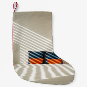 Black red and white plaid textile on white bed small christmas stocking