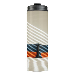 Black red and white plaid textile on white bed thermal tumbler