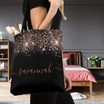 Black rose gold glitter monogram script tote bag<br><div class="desc">A chic black background decorated with rose gold glitter drops. Personalise and add a name. Rose gold coloured text. The name is written with a modern hand lettered style script with swashes. To keep the swashes only delete the sample name, leave the spaces or emoji's in front and after the...</div>