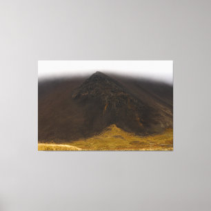 Black volcanic mountain and low clouds canvas art