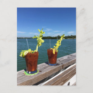 Bloody Mary drinks on a railing with ocean Postcard