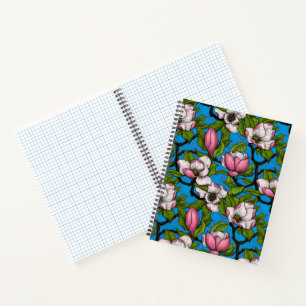 Blooming magnolia on blue notebook