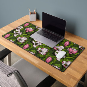 Blooming magnolia on dark green desk mat