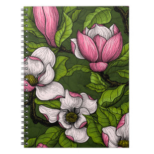 Blooming magnolia on dark green notebook